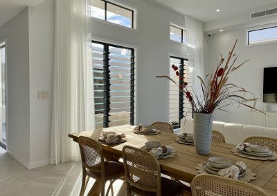 Dining area inside the beautiful La Casa Eden Display Home featuring Breezway Louvres